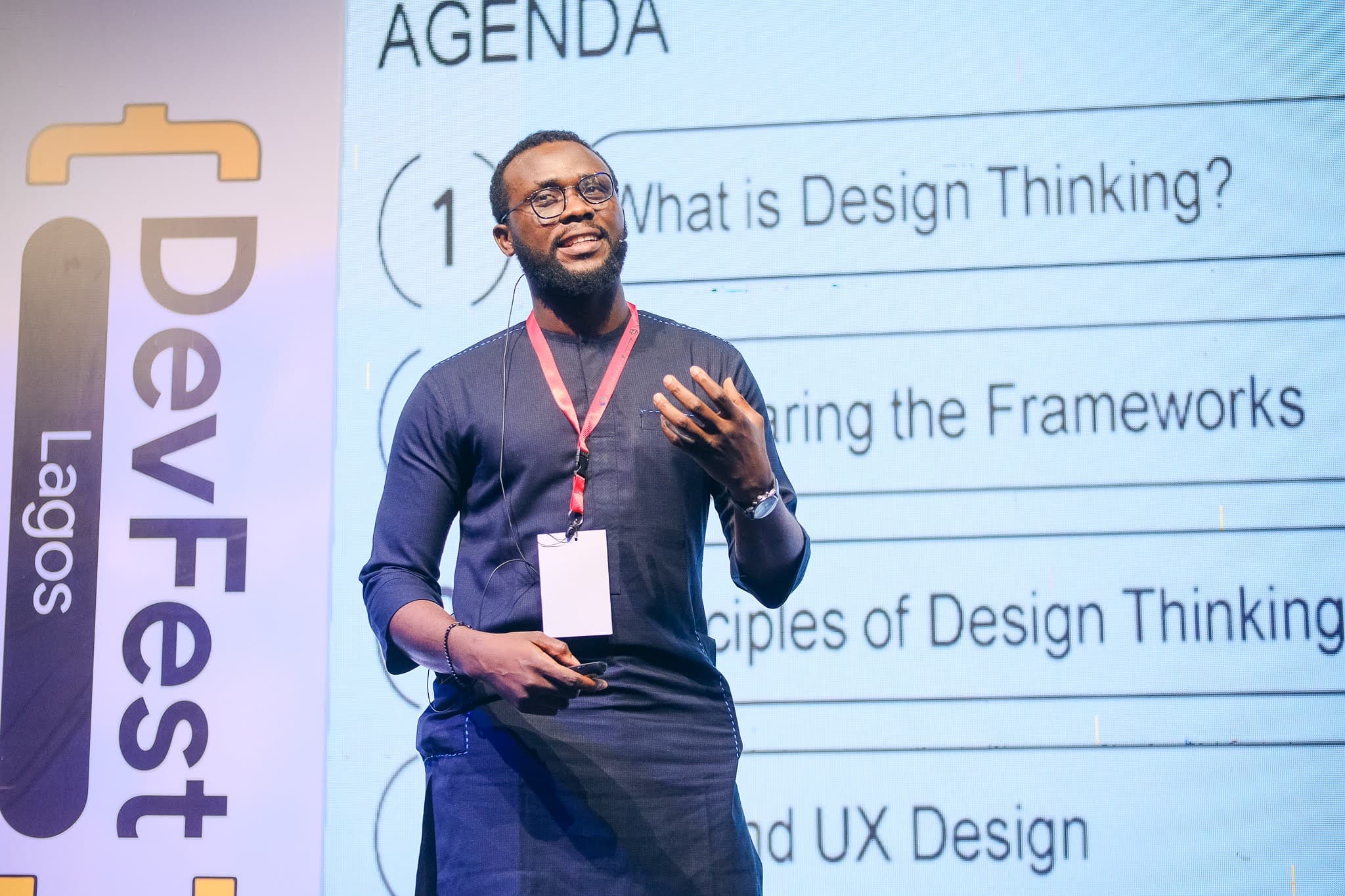 John Ohio speaking on stage at DevFest Lagos about design thinking